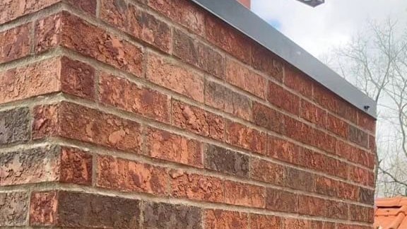 A brick chimney stack fitted with new lead flashing where it meets the roofline. A brick chimney stack fitted with new lead flashing where it meets the roofline.