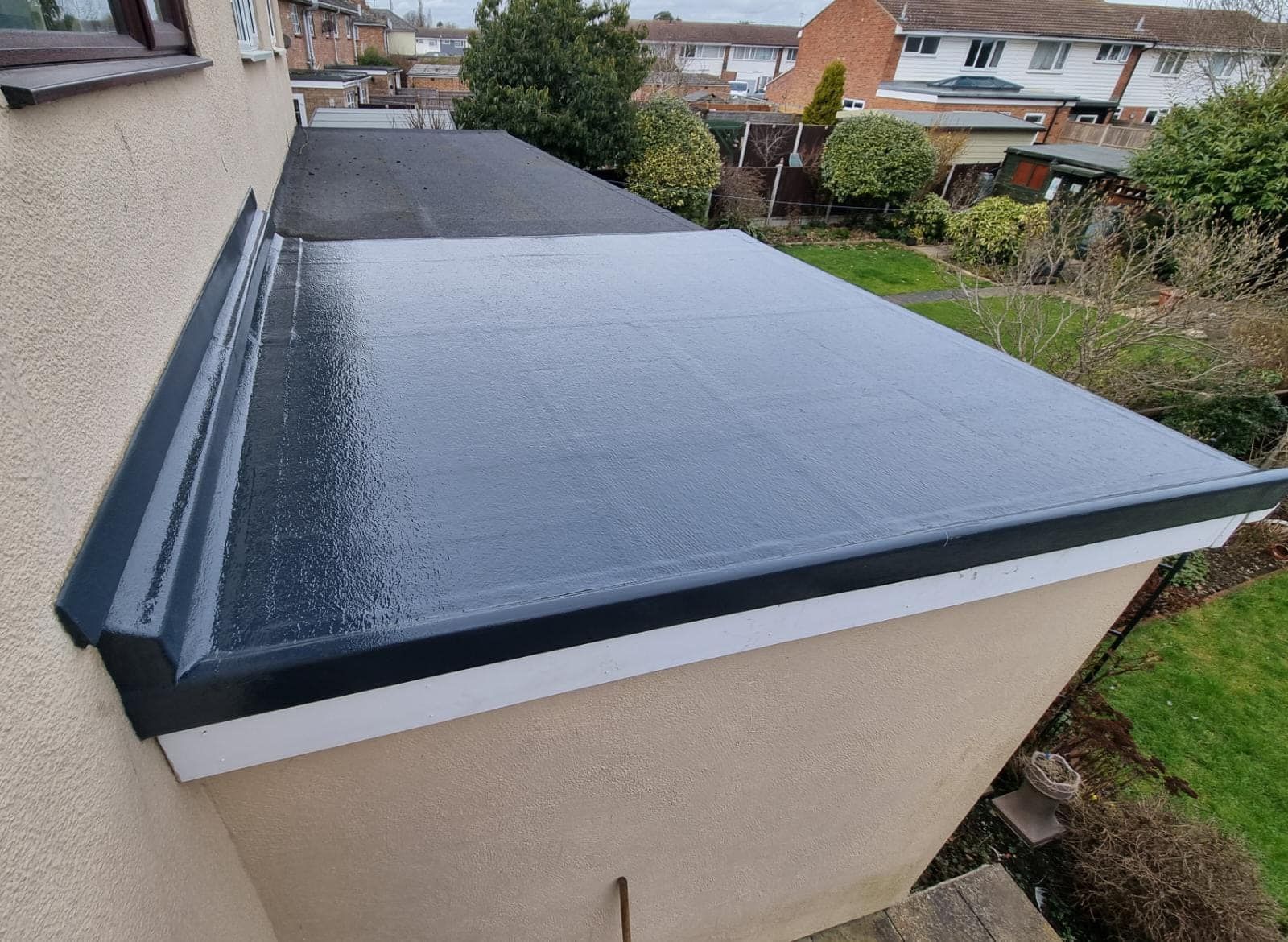 A dark grey glossy fibreglass flat roof with an upstand trim detail.