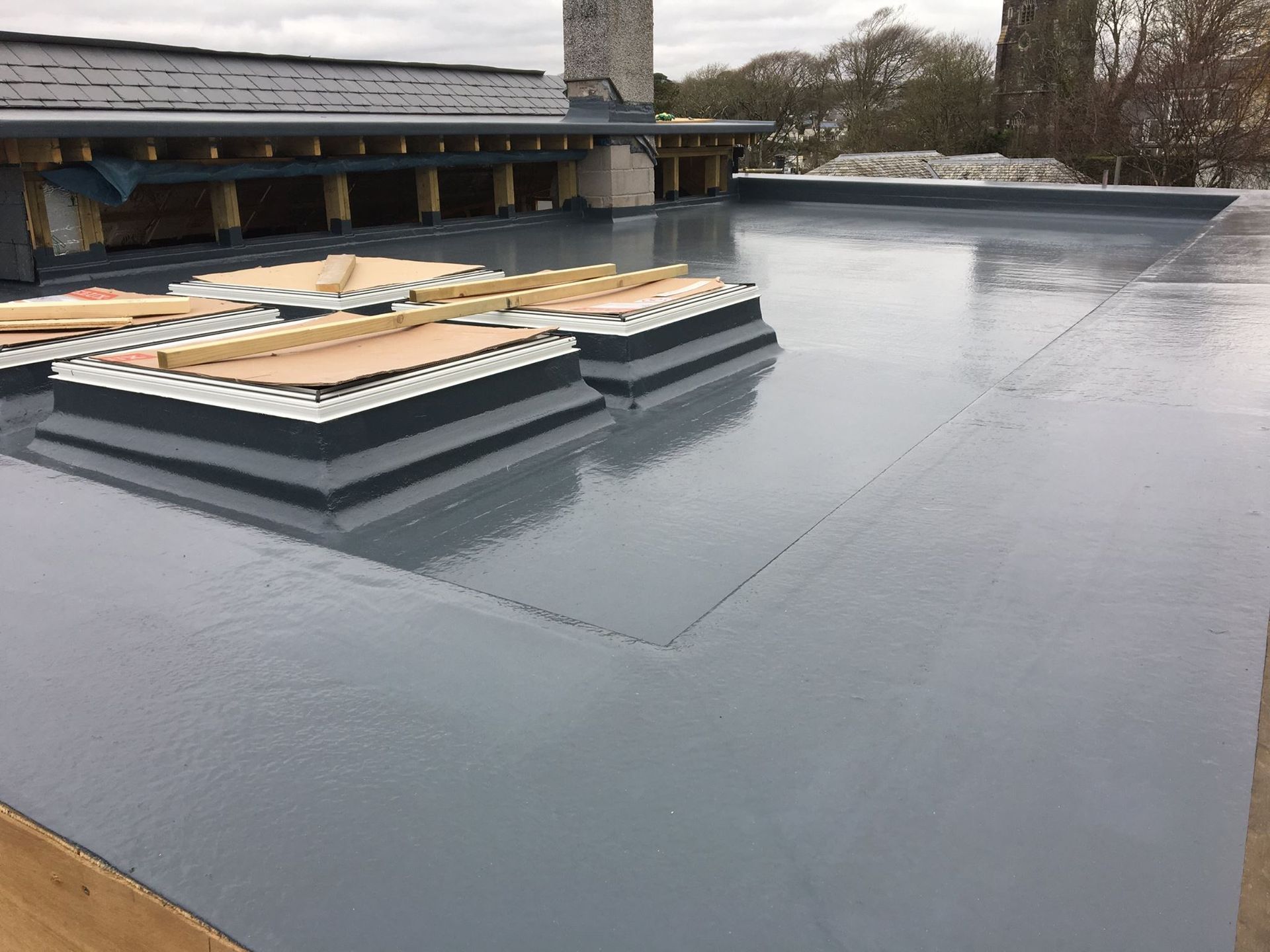 A grey GRP fibreglass flat roof with skylight upstands.