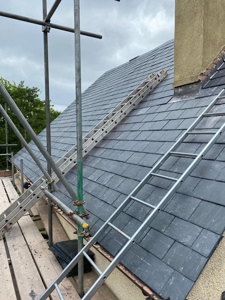 A grey slate roof with ladders in place for a close-access roof survey.