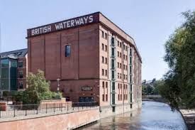 A tall red brick former warehouse building beside a river, a typical Nottingham heritage listed property. A tall red brick former warehouse building beside a river, a typical Nottingham heritage listed property.