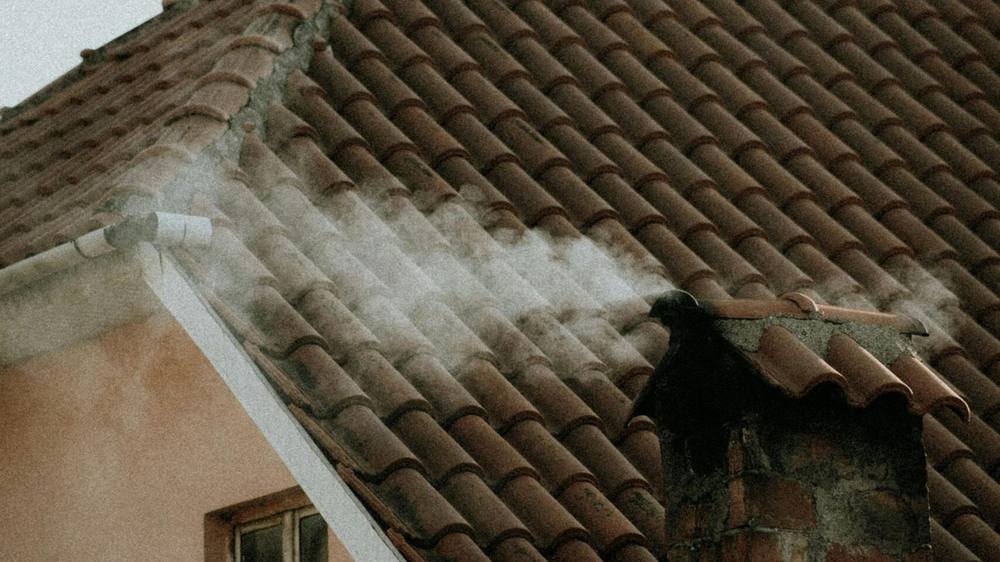 Smoke rising from a chimney on a traditional clay tile pitched roof, typical of Nottingham's older housing stock. Smoke rising from a chimney on a traditional clay tile pitched roof, typical of Nottingham's older housing stock.