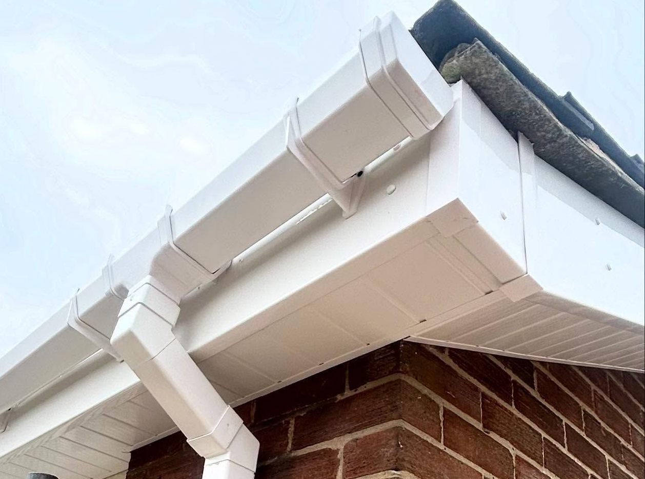Close-up of white uPVC guttering corner with downpipe.